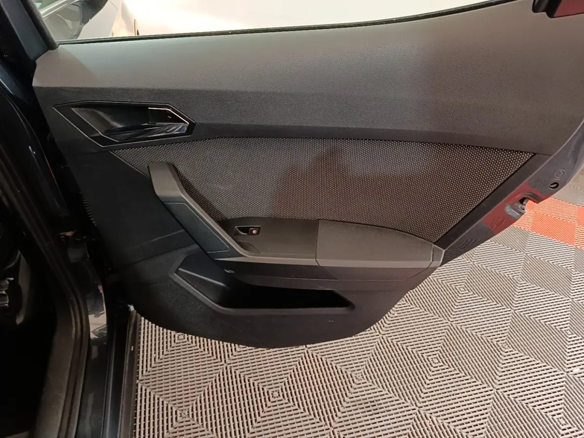 Vue rapprochée de la porte arrière gauche noire du SEAT Arona 2019, avec poignée intégrée et panneau texturé.