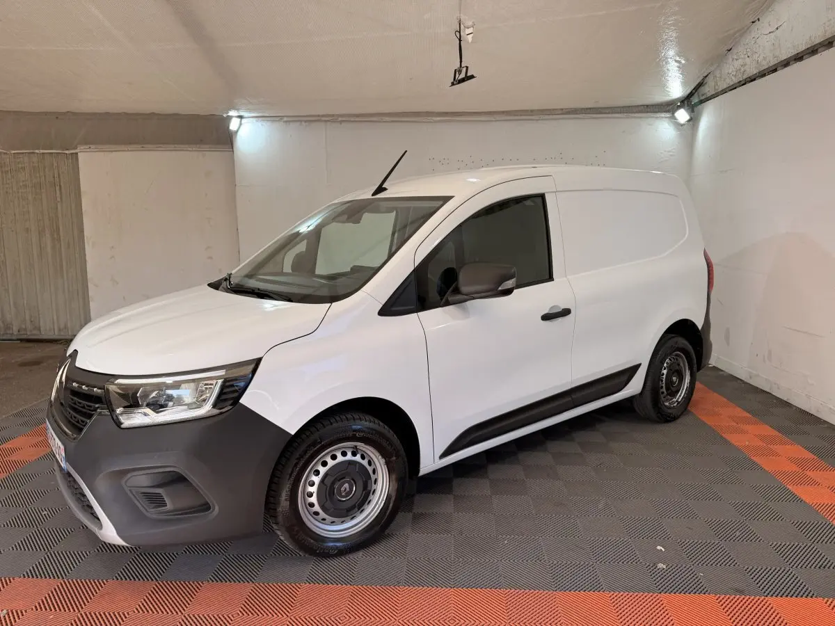 Renault Kangoo blanc en 3/4 avant droit, fourgonnette utilitaire avec pare-chocs noir et jantes acier.