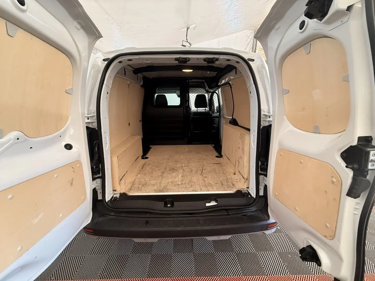 Vue arrière ouverte du Renault Kangoo blanc 2022, montrant l’espace de chargement avec panneaux en bois et séparation intérieure.