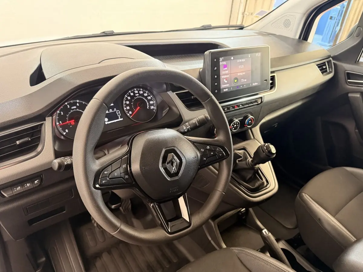 Vue intérieure du poste de conduite du Renault Kangoo 2022 avec volant, tableau de bord et écran tactile central.