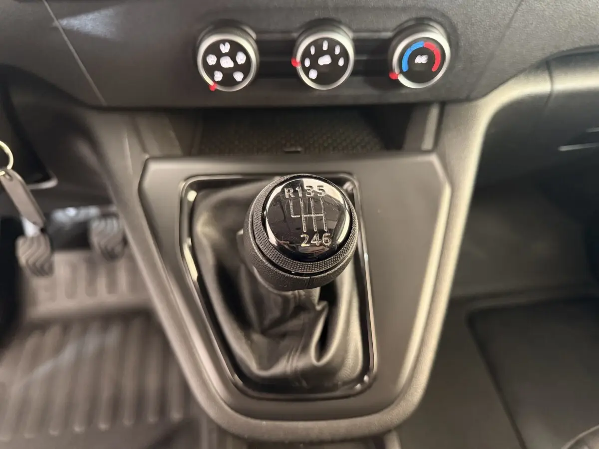 Le levier de vitesses manuel du Renault Kangoo 2022 en gros plan, avec commandes de climatisation visibles en arrière-plan.