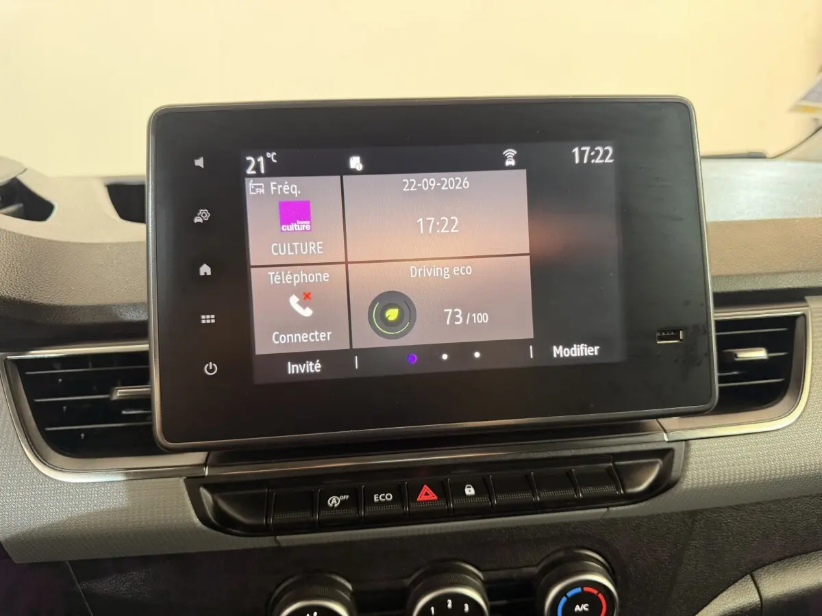 Écran tactile central du tableau de bord du Renault Kangoo 2022 blanc, affichant l'interface multimédia et climatisation.
