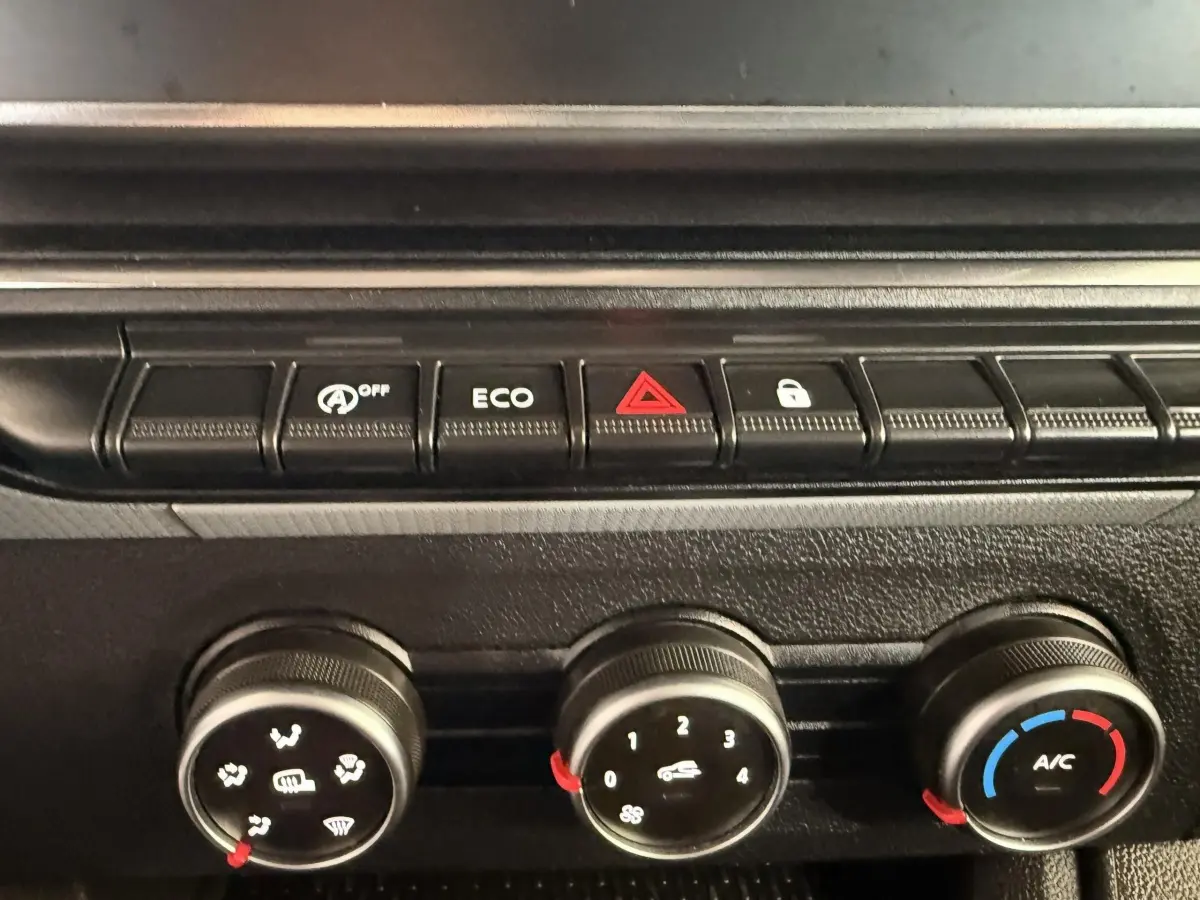 Image intérieure montrant la console centrale du Renault Kangoo 2022 avec commandes climatisation et boutons fonctionnels.