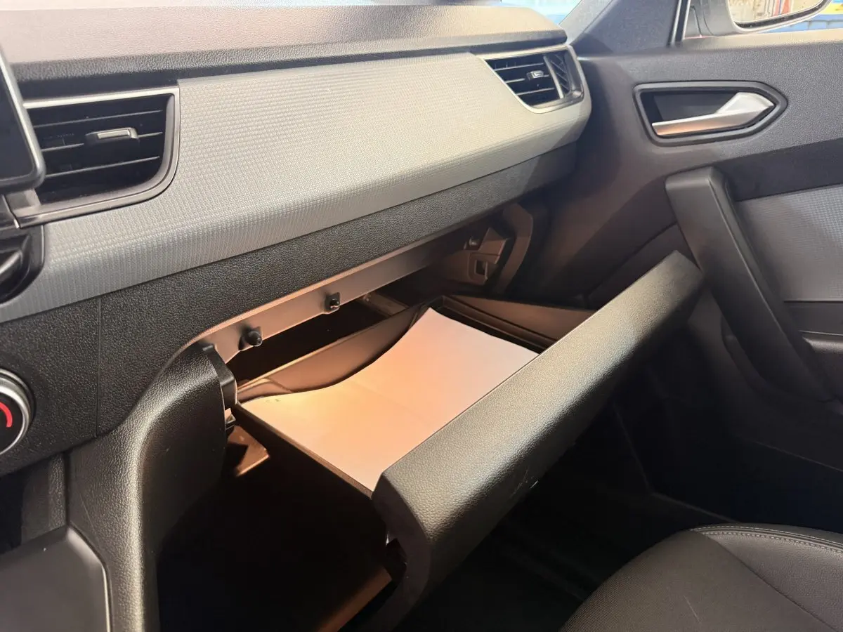 Intérieur du Renault Kangoo 2022, vue côté passager sur la boîte à gants ouverte avec un document blanc visible.