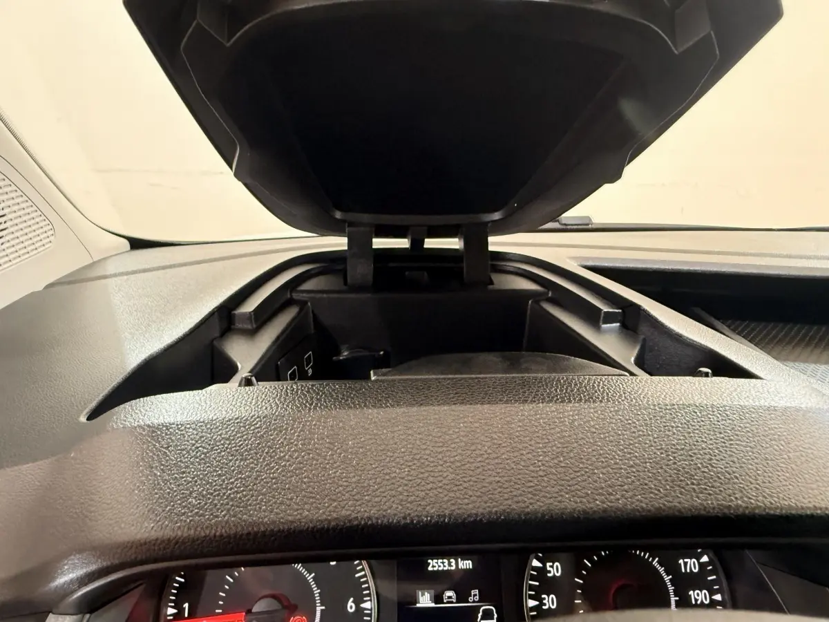Vue rapprochée de la console centrale ouverte et du tableau de bord noir du Renault Kangoo blanc 2022.