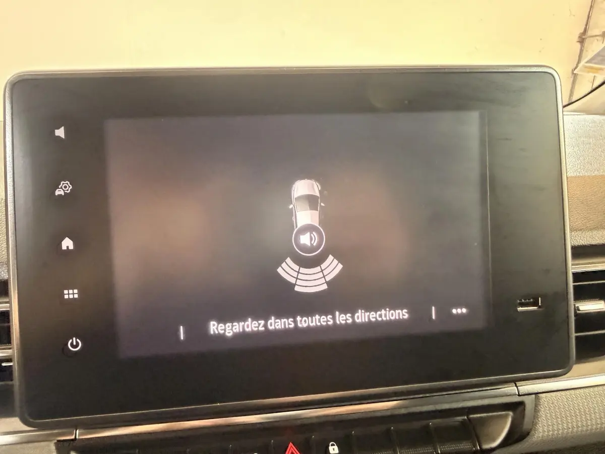 Écran tactile intérieur du Renault Kangoo 2022 montrant l'alerte de proximité avec message "Regardez dans toutes les directions".