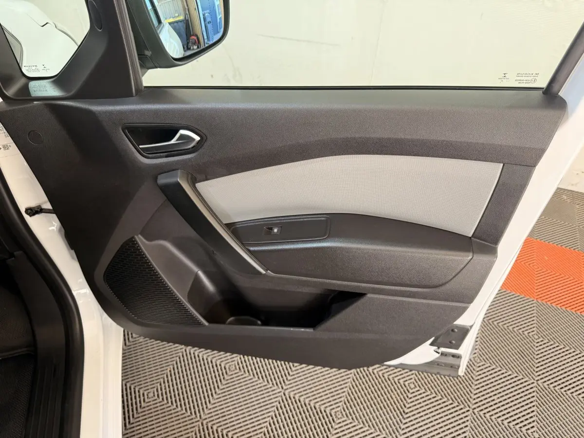 Vue intérieure côté gauche de la porte avant blanche du Renault Kangoo 2022, avec panneau bicolore noir et gris.