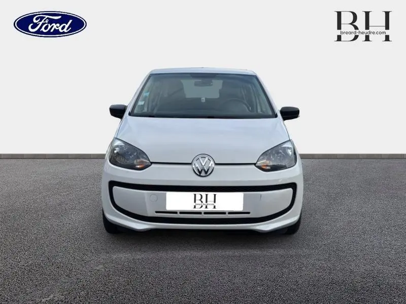 Vue frontale d'une Volkswagen Up blanche Candy de 2014 avec phares halogènes et logo VW bien visible.