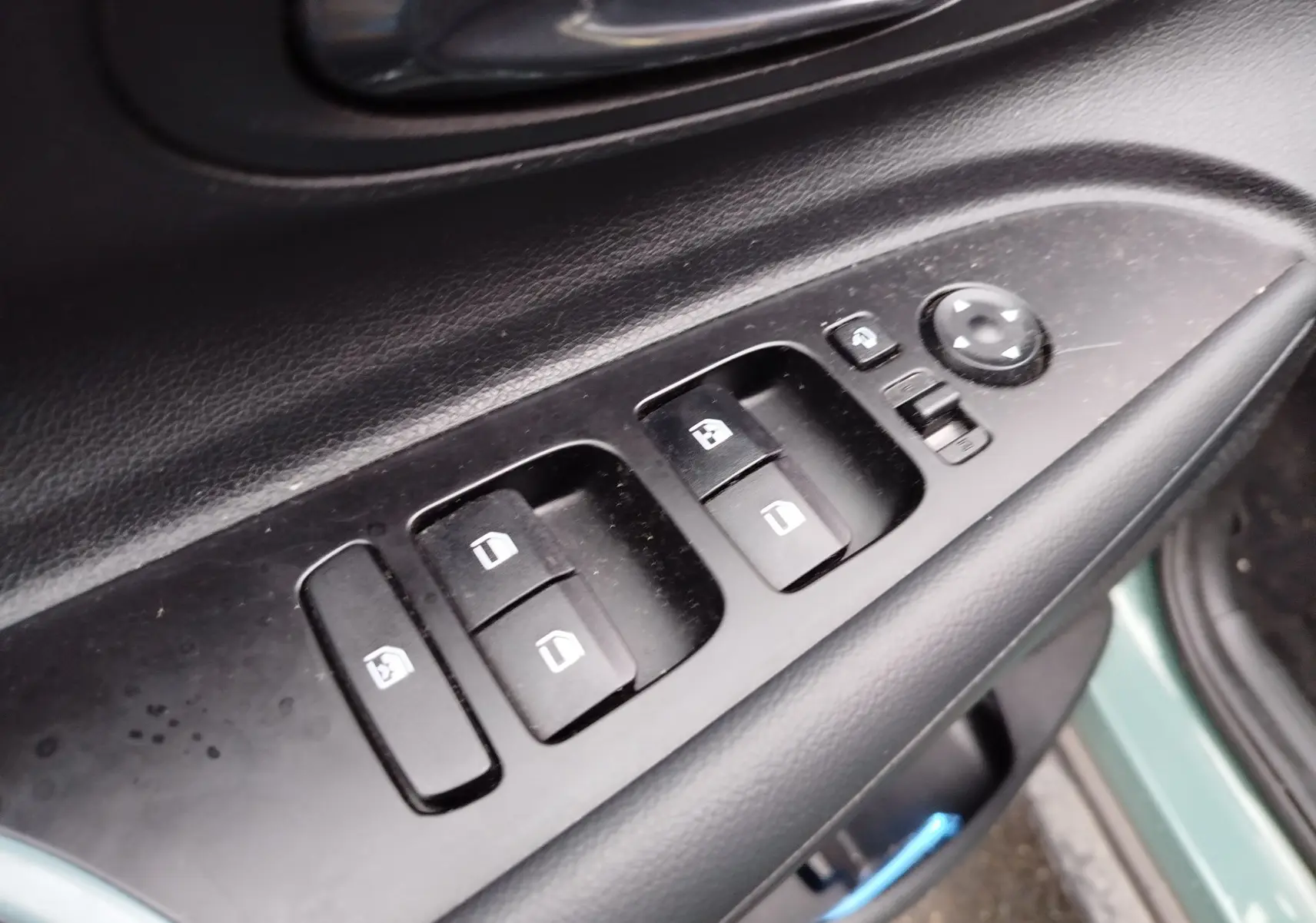 Gros plan sur les commandes de lève-vitres et rétroviseurs côté conducteur du Hyundai Bayon 2022 couleur Elemental Brass Metal.