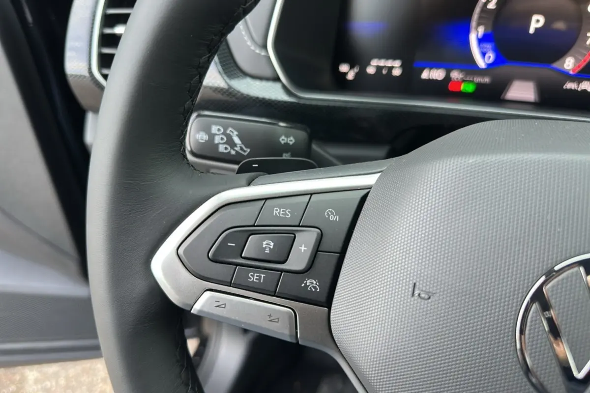 Gros plan sur le volant cuir noir du Volkswagen T-Cross 2025 TSI 116 DSG7 R-Line avec commandes multifonctions.