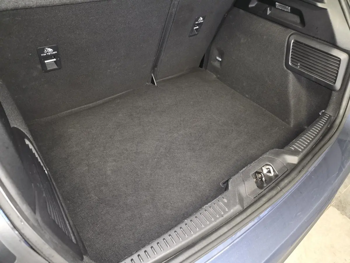 Vue plongeante sur le coffre vide de la Ford Focus 2024 bleu azur, avec revêtement noir et finitions soignées.