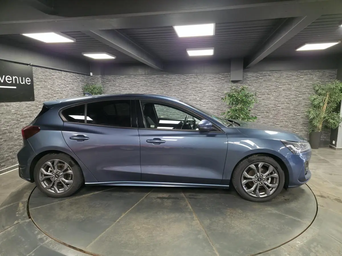 Profil droit de la Ford Focus 2024 bleu métallisé avec jantes alliage 17'' et vitres surteintées.