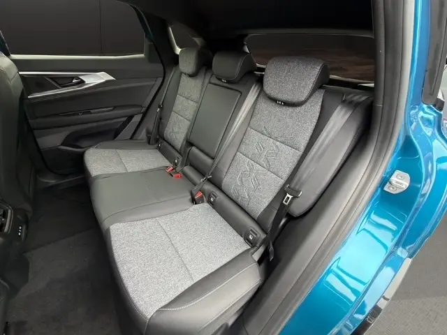 Vue côté droit de la banquette arrière bi-matière grise et noire du Renault Austral bleu, avec ceinture et appuie-tête visibles.