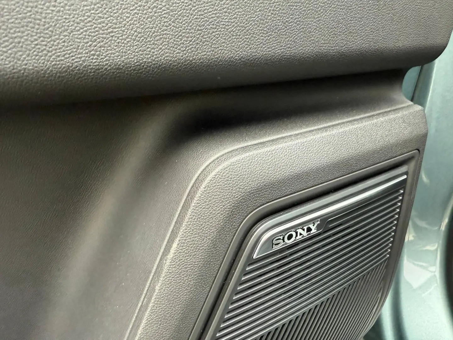 Détail du haut-parleur Sony intégré dans la porte côté droit du JAECOO J7 Olive Grey Métal.