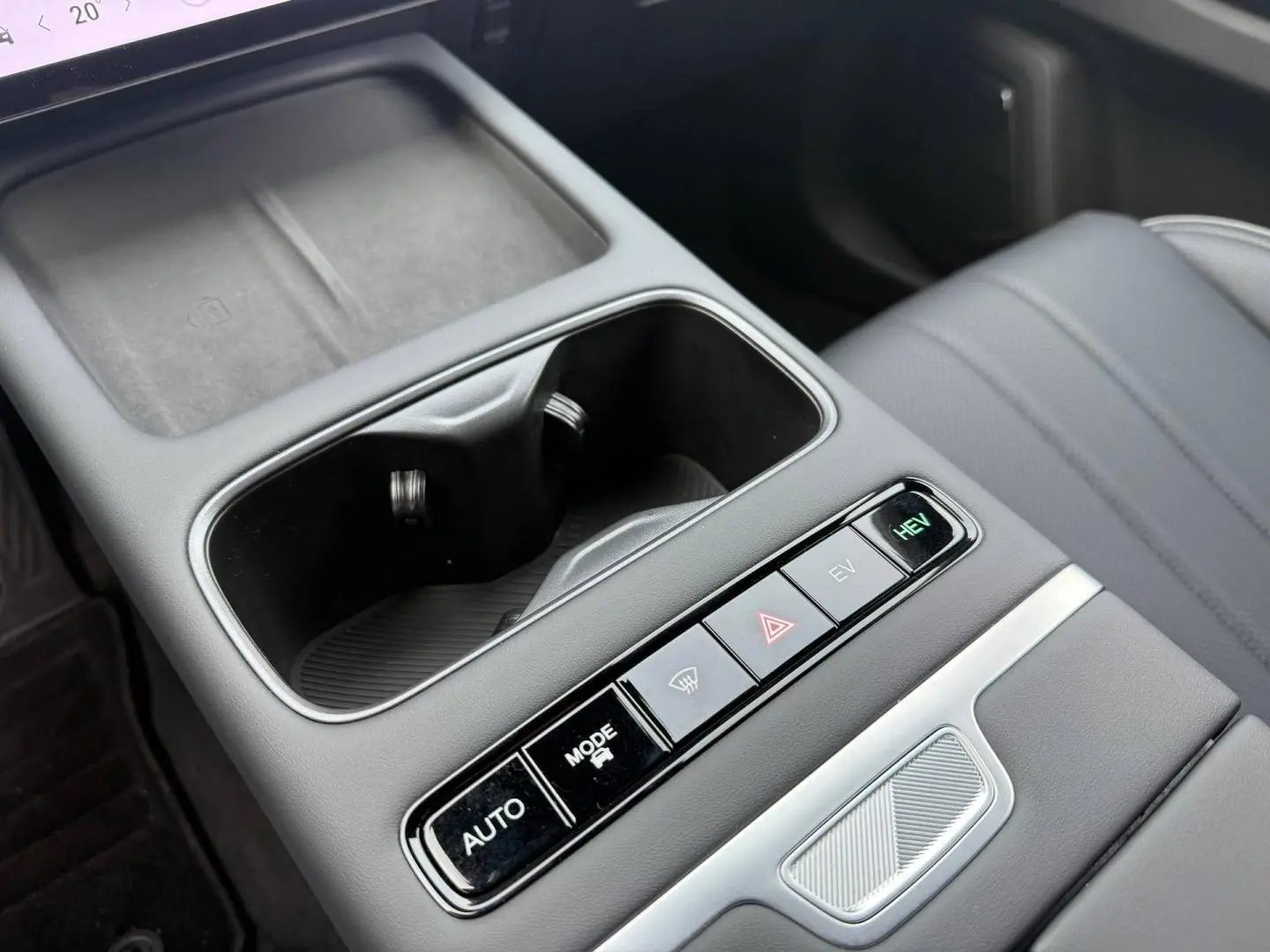 Gros plan sur la console centrale noire avec porte-gobelets et boutons de modes de conduite du JAECOO J7 hybride.