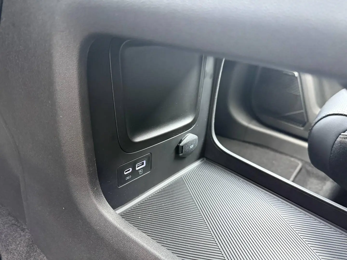 Détail de la console centrale côté passager avec prises USB et prise 12V dans le JAECOO J7 hybride 2026.
