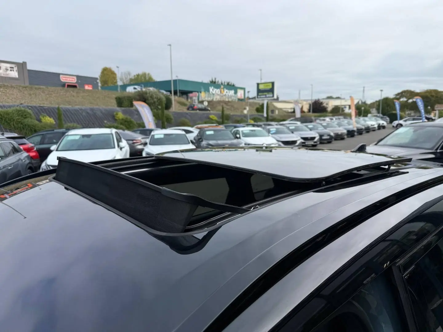 Toit ouvrant panoramique ouvert sur le dessus d'un JAECOO J7 Olive Grey Métal avec toit Carbon Crys Black, vue en plongée.