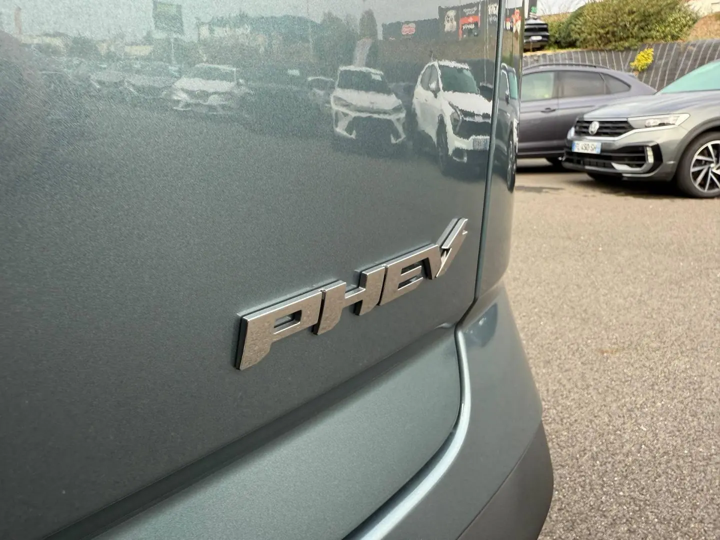 Gros plan sur l'arrière olive grey métal d'un JAECOO J7 hybride rechargeable avec badge PHEV visible.
