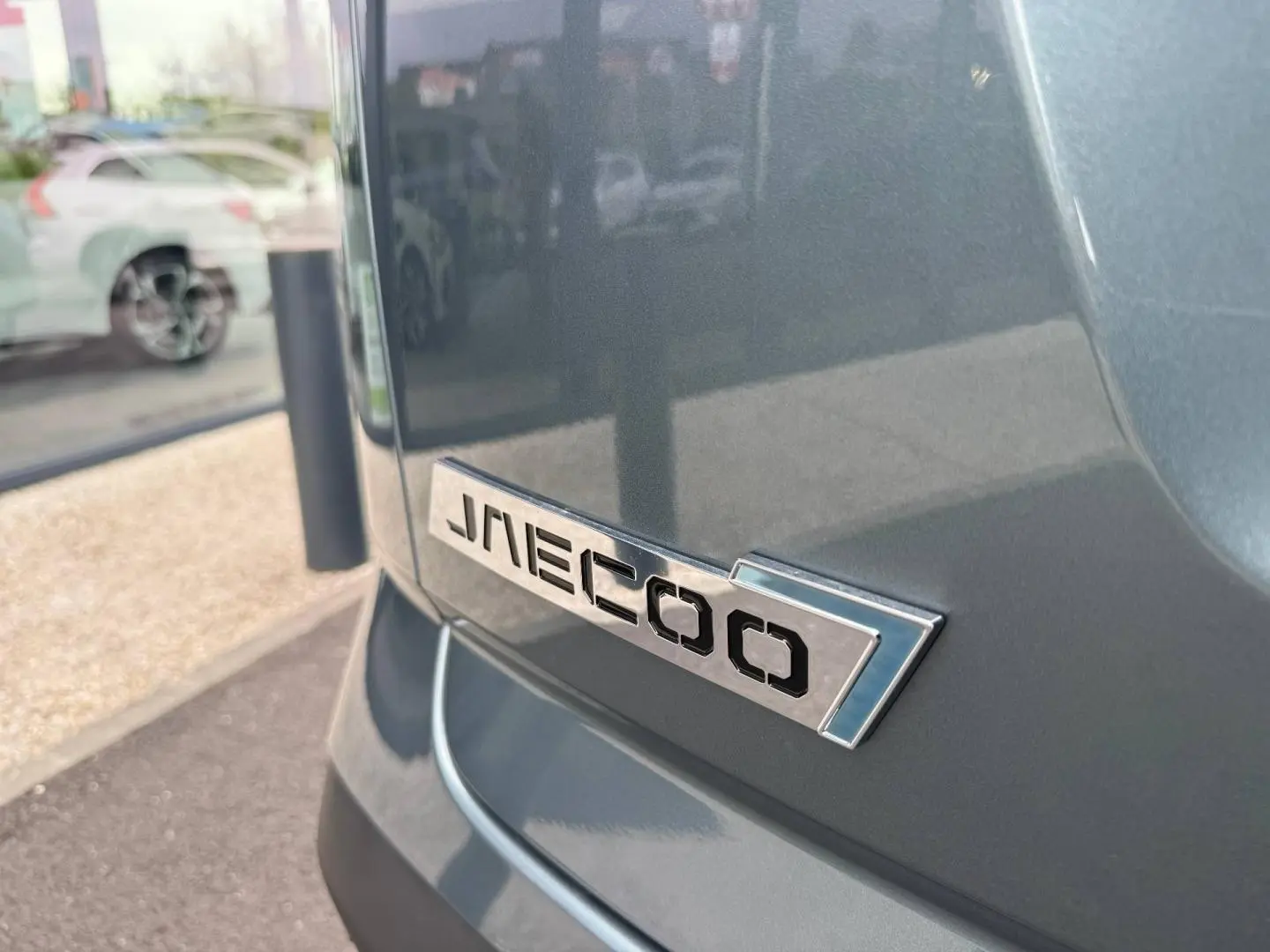 Gros plan sur l'arrière droit du JAECOO J7 olive grey métal avec logo chromé sur la carrosserie.