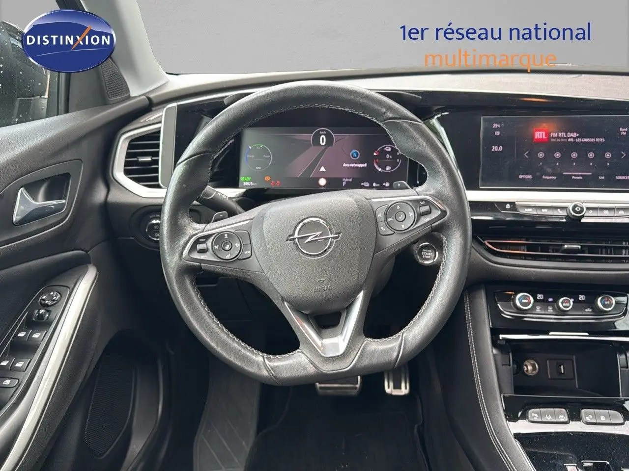 Vue intérieure frontale du volant en cuir noir et du tableau de bord numérique de l'Opel Grandland 2024 hybride rechargeable.