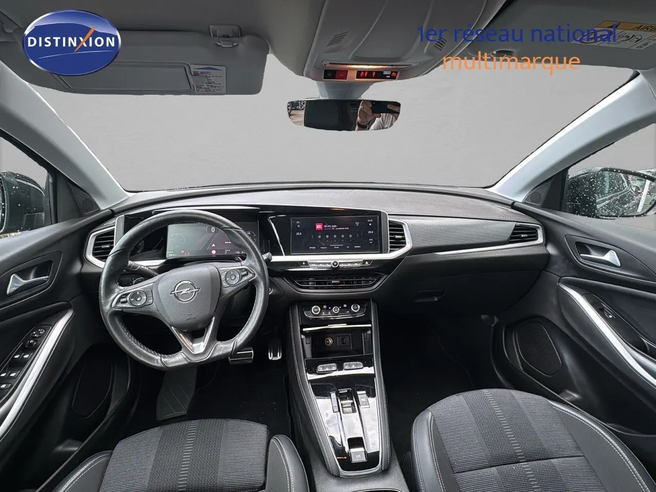 Intérieur noir de l'Opel Grandland 2024, vue frontale du poste de conduite avec tableau de bord numérique et écran tactile central.