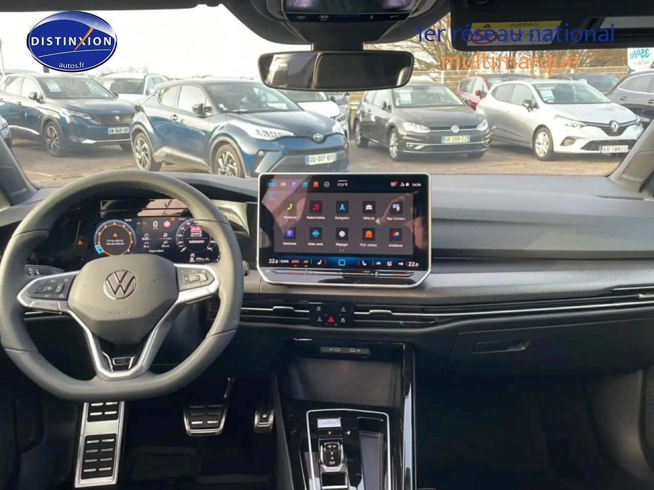 Vue intérieure avant de la Volkswagen Golf gris 2026, volant multifonction et écran tactile central lumineux.