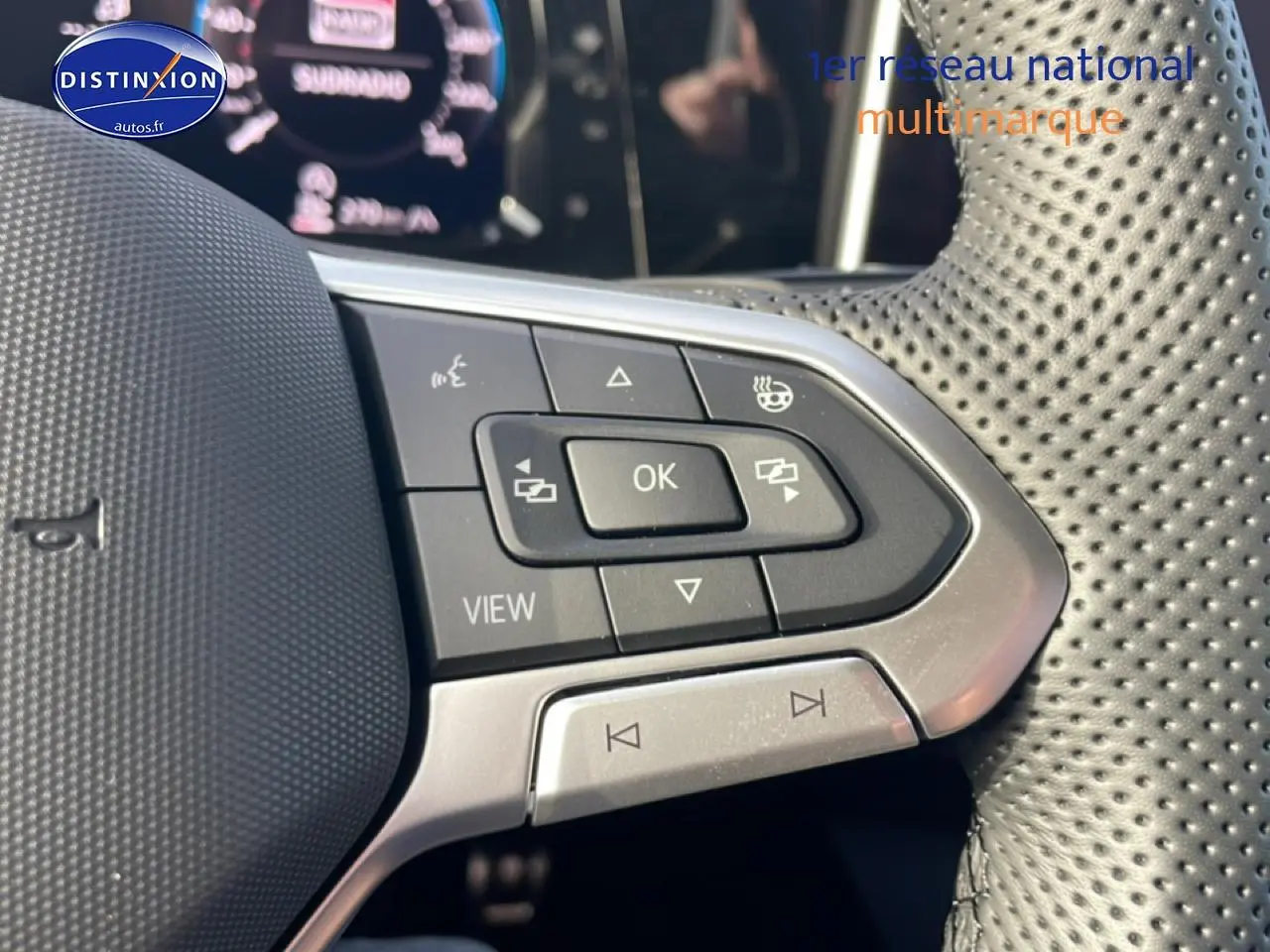 Gros plan sur les commandes multifonctions du volant cuir perforé de la Volkswagen Golf gris 2026.