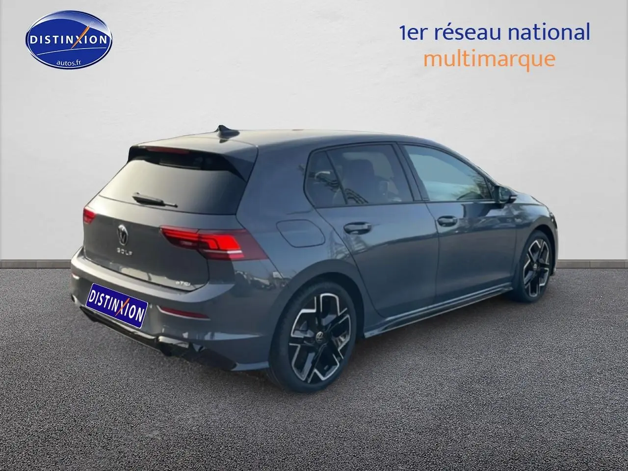 Volkswagen Golf gris 3/4 arrière droit avec jantes alu noires et vitres arrière surteintées.