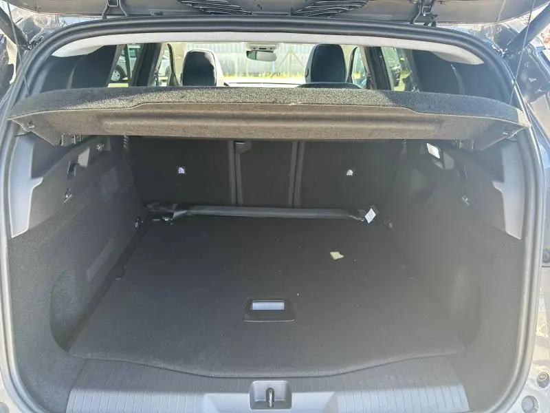 Coffre ouvert vu de l'arrière du Citroën C5 Aircross gris Platinium, espace de chargement spacieux et tapis noir.