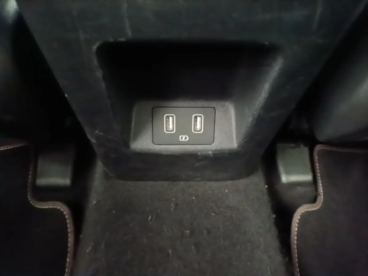 Prise USB double pour recharge située à l'arrière de la console centrale dans l'habitacle noir du Hyundai Tucson blanc.