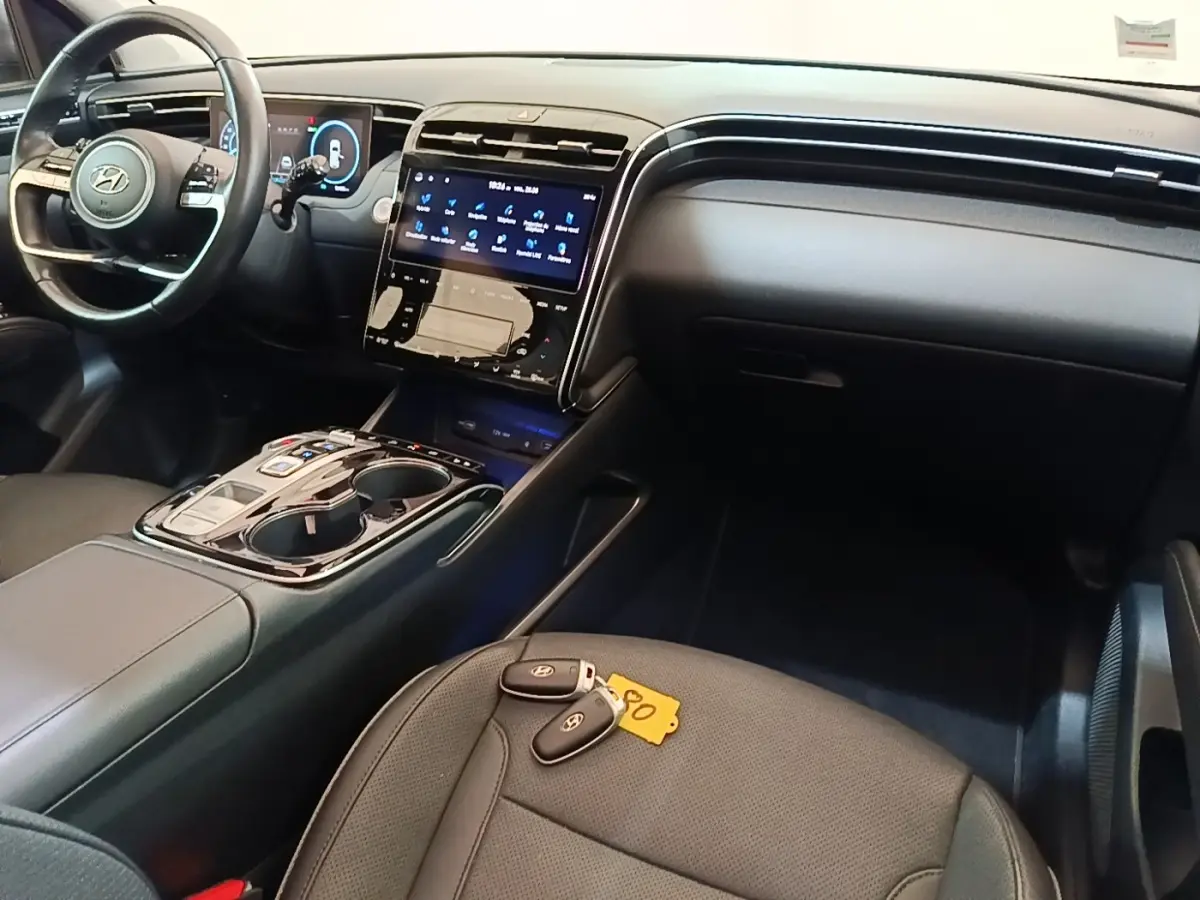 Intérieur noir du Hyundai Tucson 1.6 Hybrid 2022 vu côté passager, avec tableau de bord et clés sur siège avant.