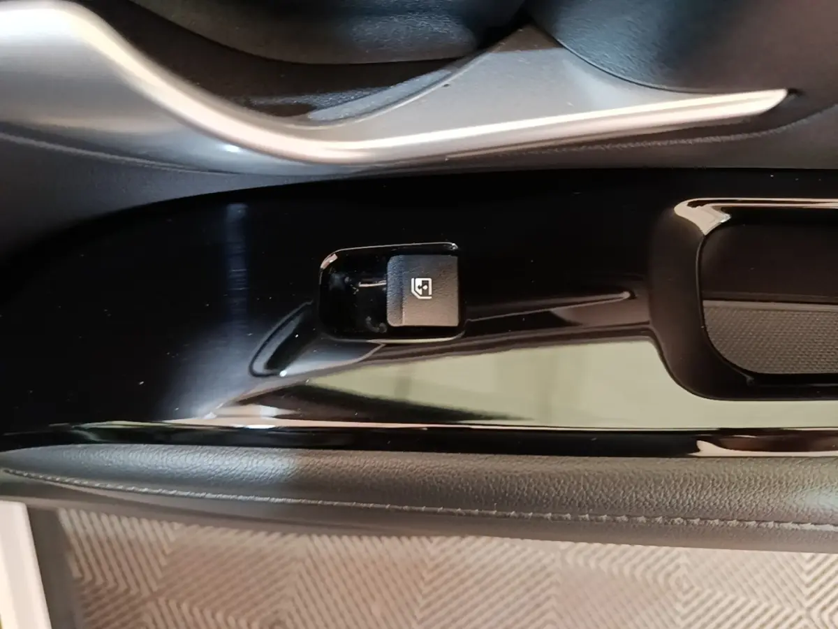 Gros plan sur la commande de verrouillage des portes côté conducteur du Hyundai Tucson blanc 1.6 Hybrid 230 Executive.