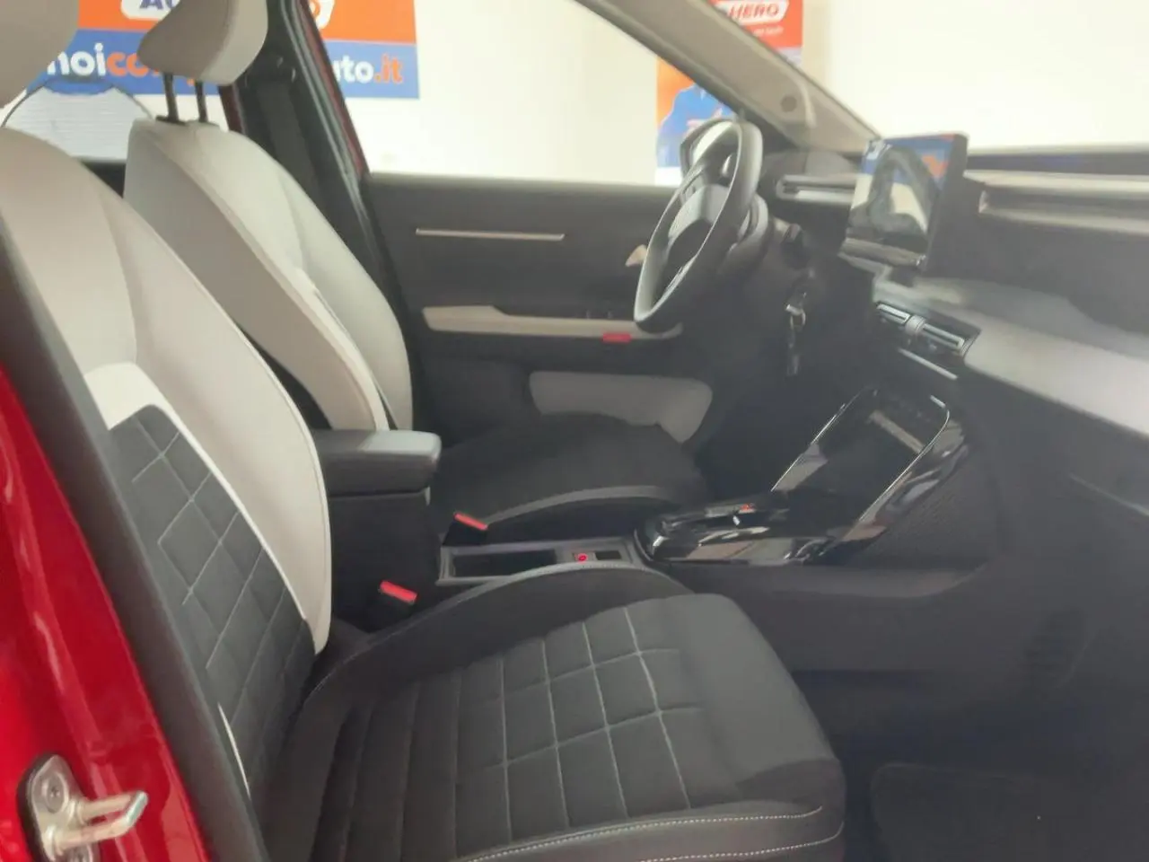 Intérieur côté gauche de la Citroën C3 ë-113 Berline Max 2025, sièges bicolores noirs et blancs, tableau de bord moderne.