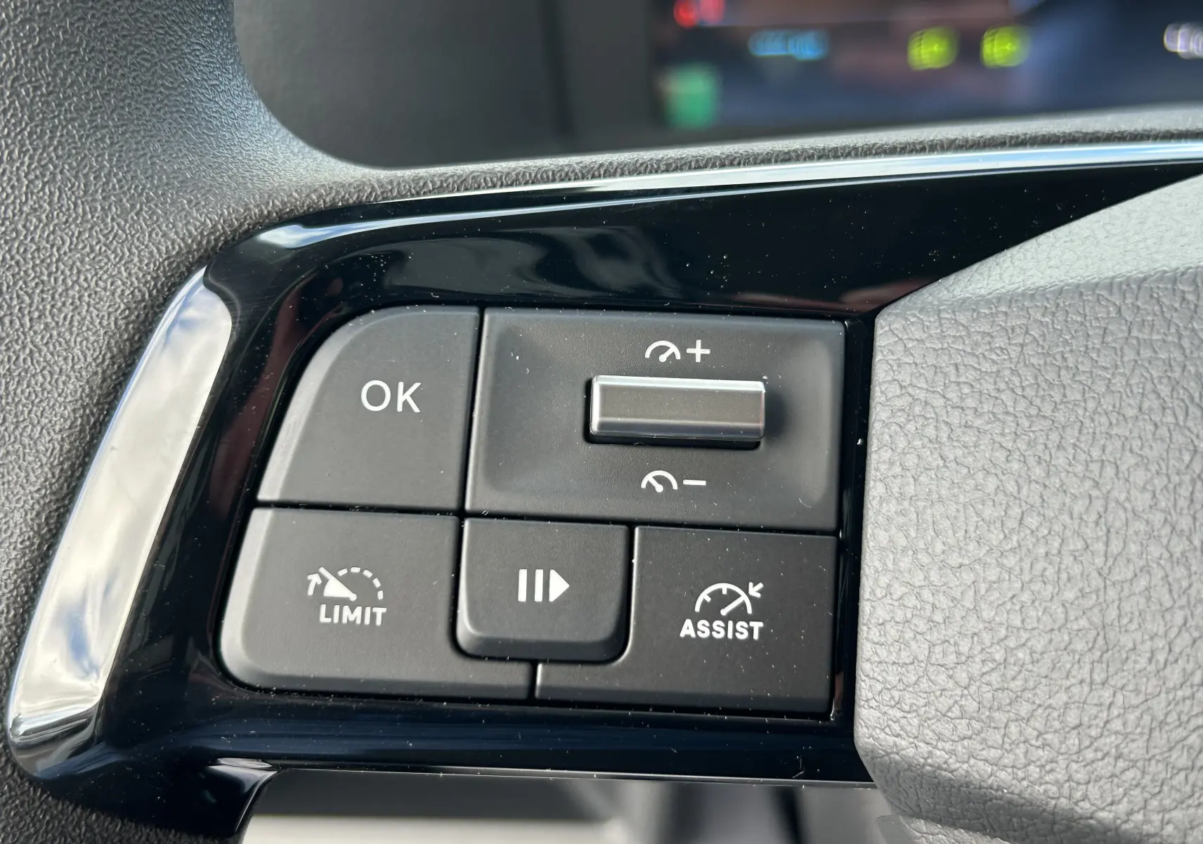 Gros plan sur les commandes au volant côté gauche du Citroën Jumpy 2025, boutons noirs avec fonctions limiteur et assist.