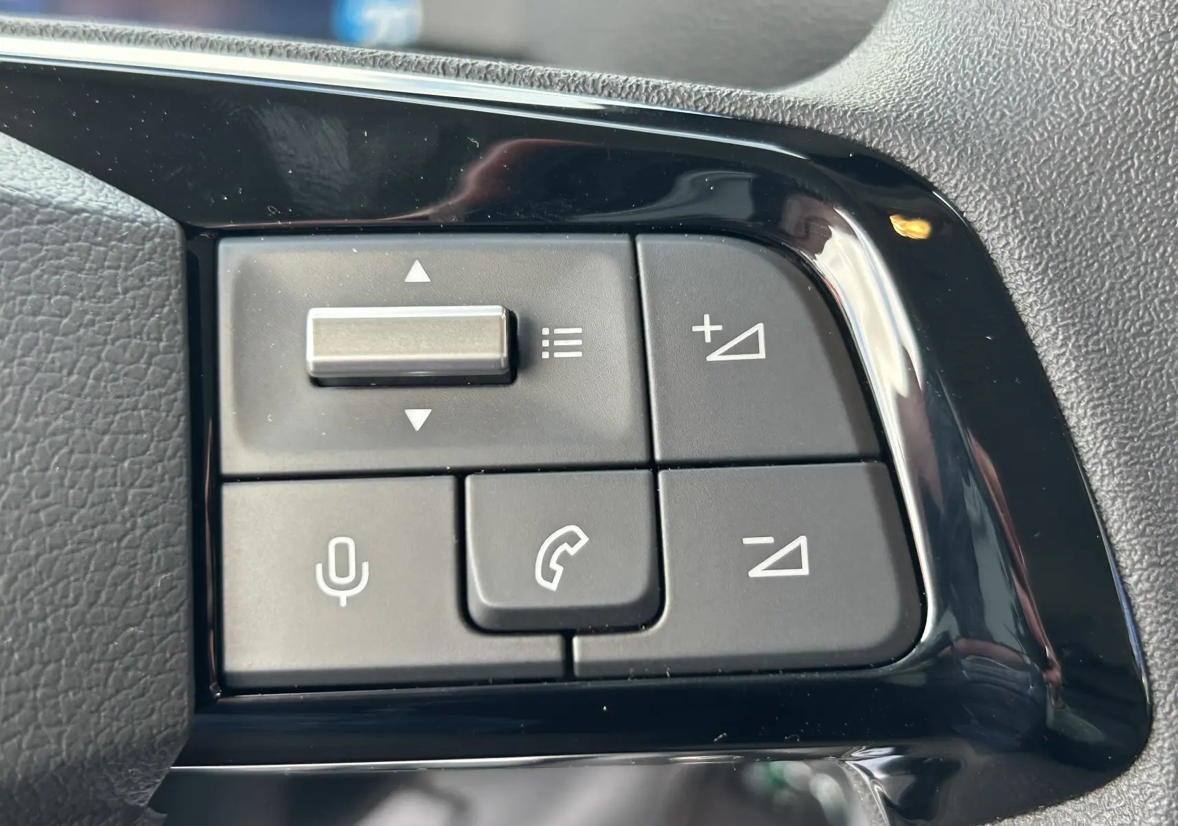 Gros plan sur les commandes au volant côté gauche du Citroën Jumpy blanc, boutons de volume et téléphone visibles.