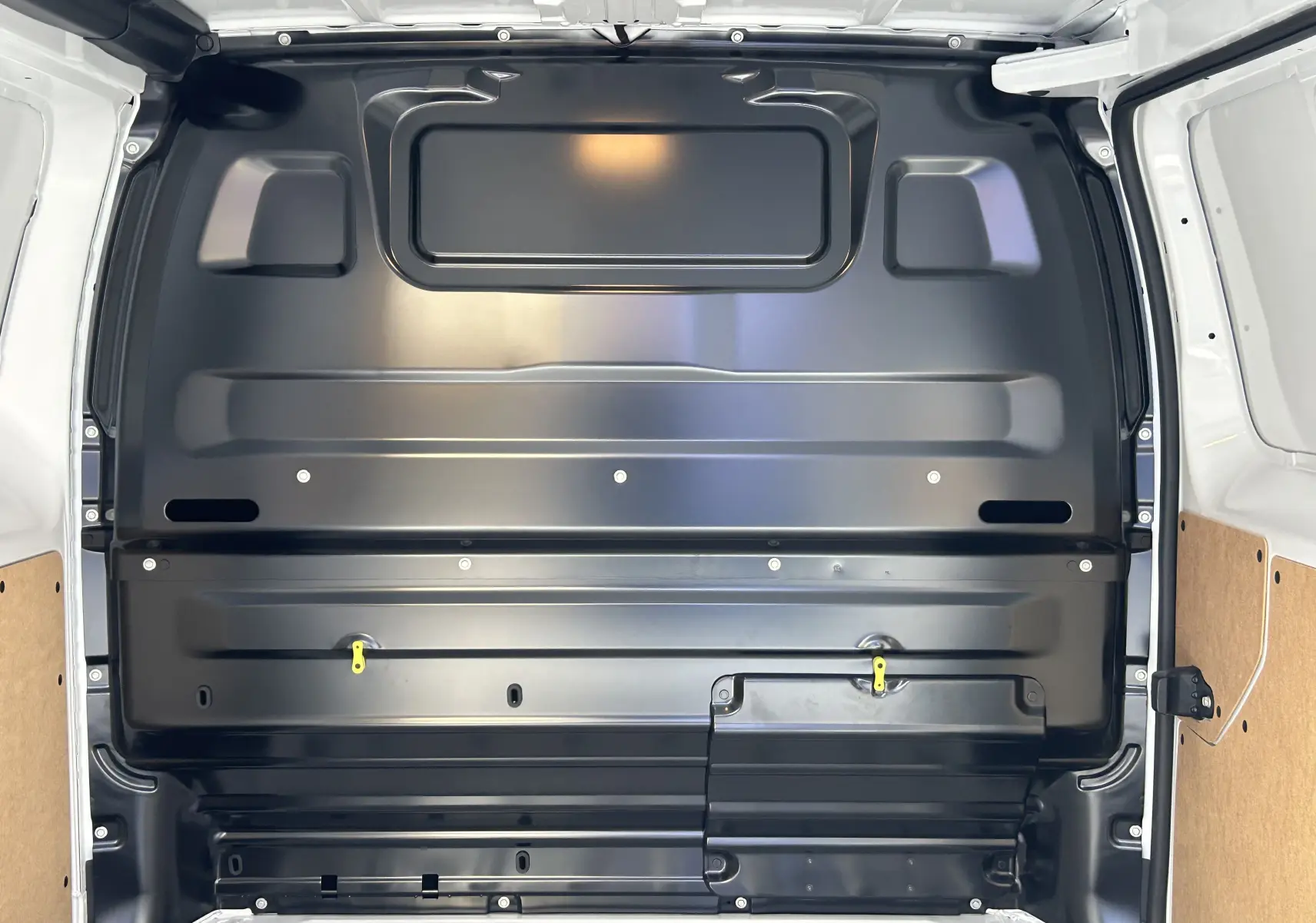 Vue intérieure arrière du fourgon blanc Citroën Jumpy 2025, montrant la cloison métallique noire séparant la cabine et la zone de chargement.