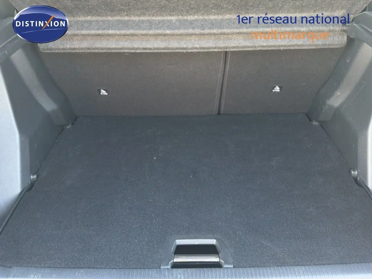 Coffre ouvert de la Peugeot 2008 gris platinium, vue intérieure montrant l'espace de chargement vide et le revêtement noir.