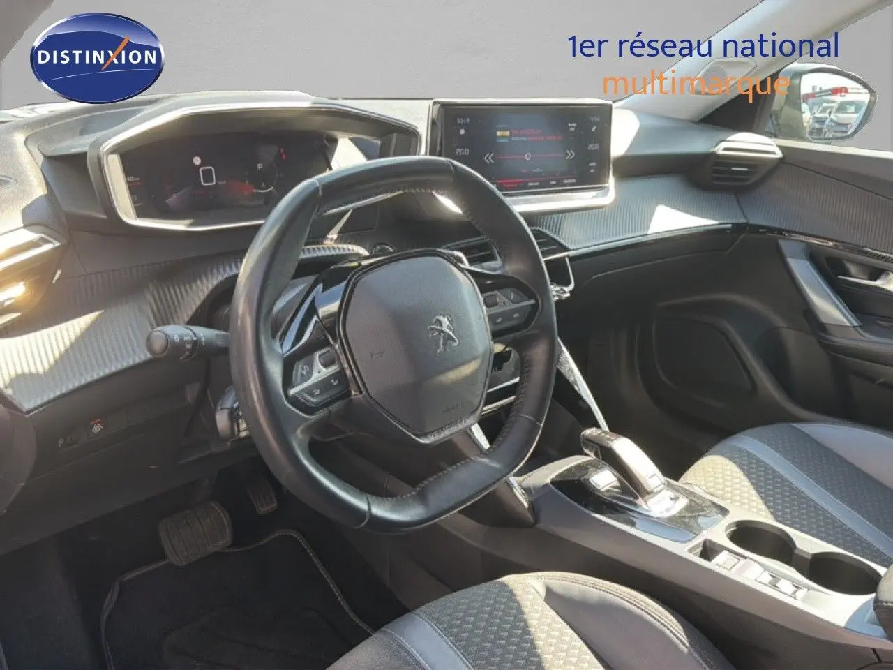 Vue intérieure côté conducteur du Peugeot 2008 gris platinium, mettant en valeur le volant compact et la console centrale moderne.