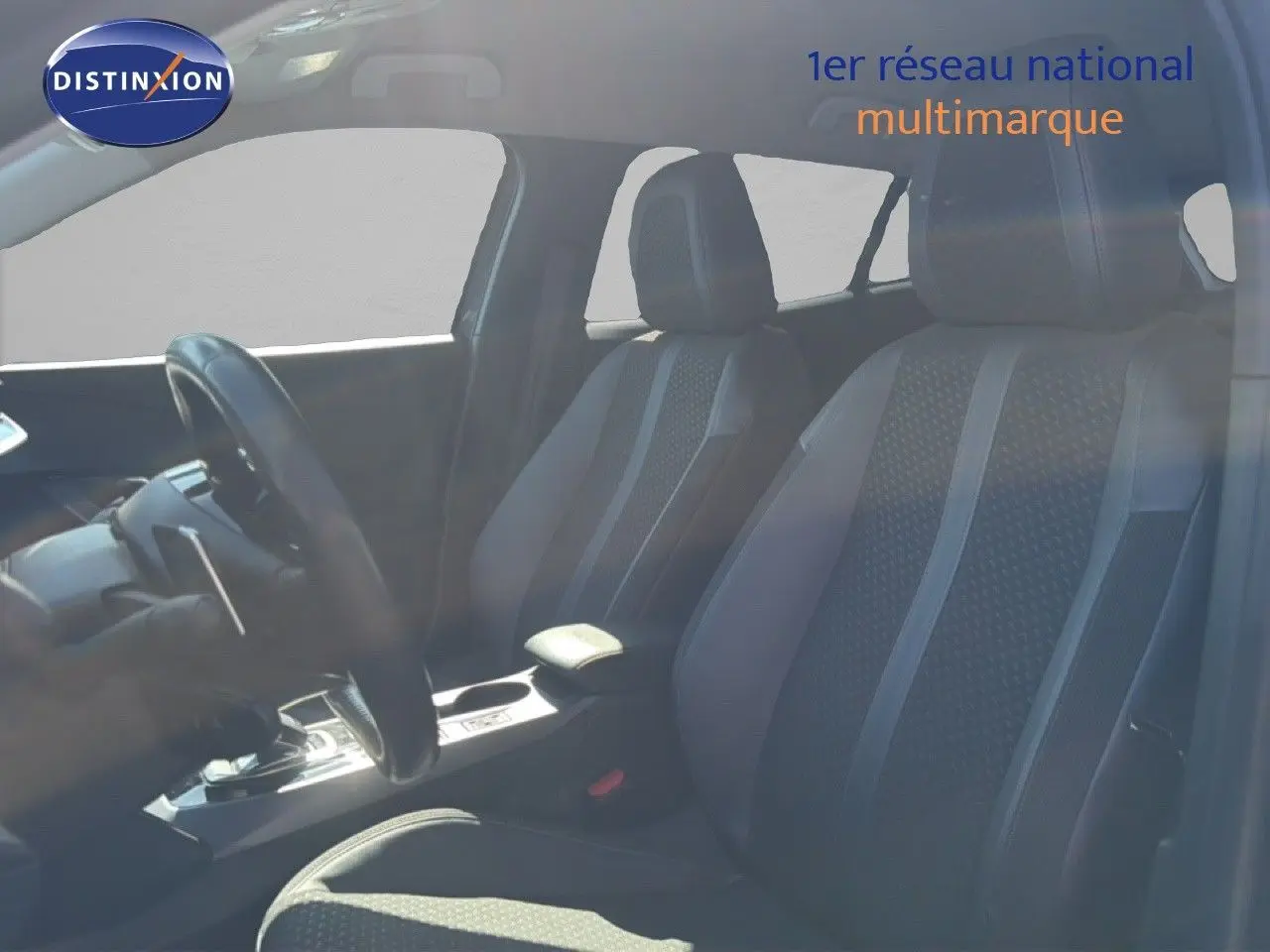 Vue intérieure côté conducteur du Peugeot 2008 gris platinium, mettant en valeur les sièges en tissu et cuir noir.