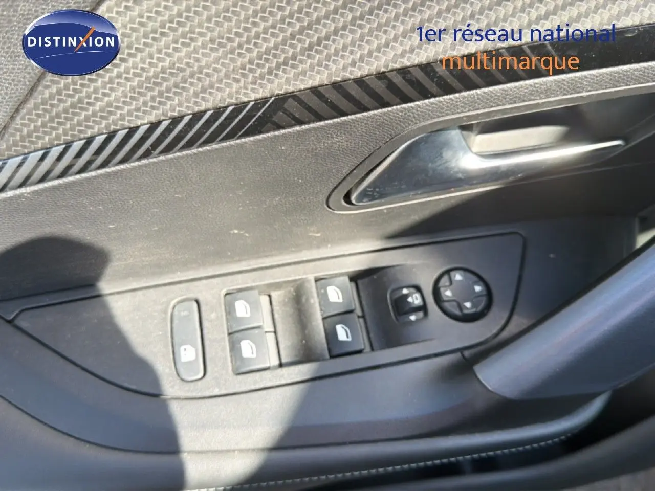 Gros plan sur la commande des vitres et rétroviseurs côté conducteur d'une Peugeot 2008 gris platinium.