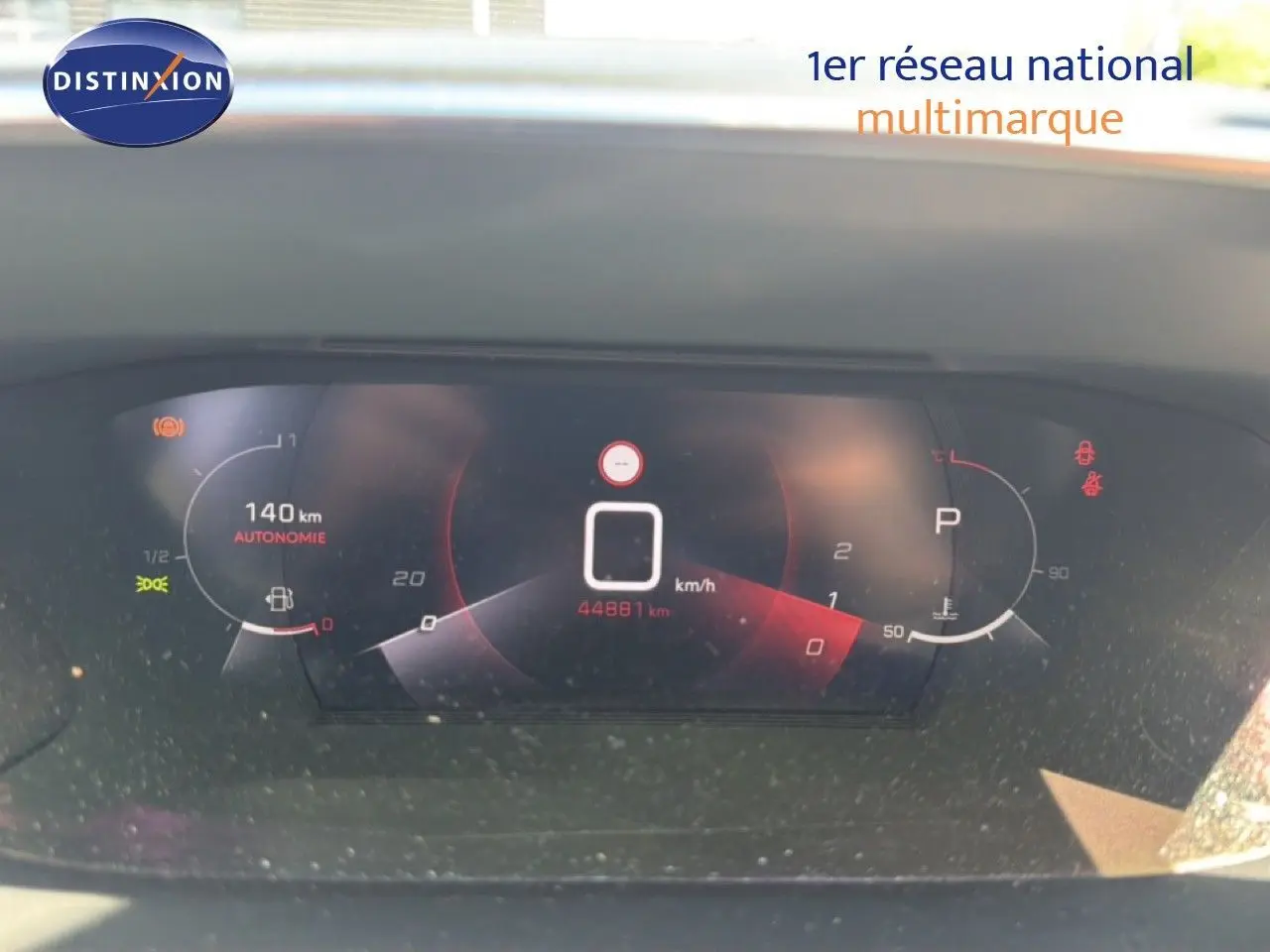 Tableau de bord numérique de Peugeot 2008 gris platinium, affichant vitesse à 0 km/h et autonomie de 140 km.