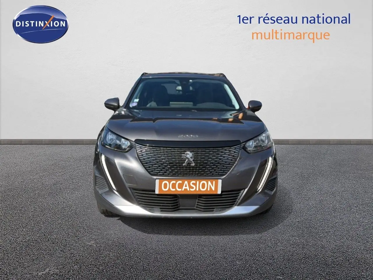 Vue frontale d'un Peugeot 2008 gris platinium avec calandre noire et plaque orange "OCCASION" visible.