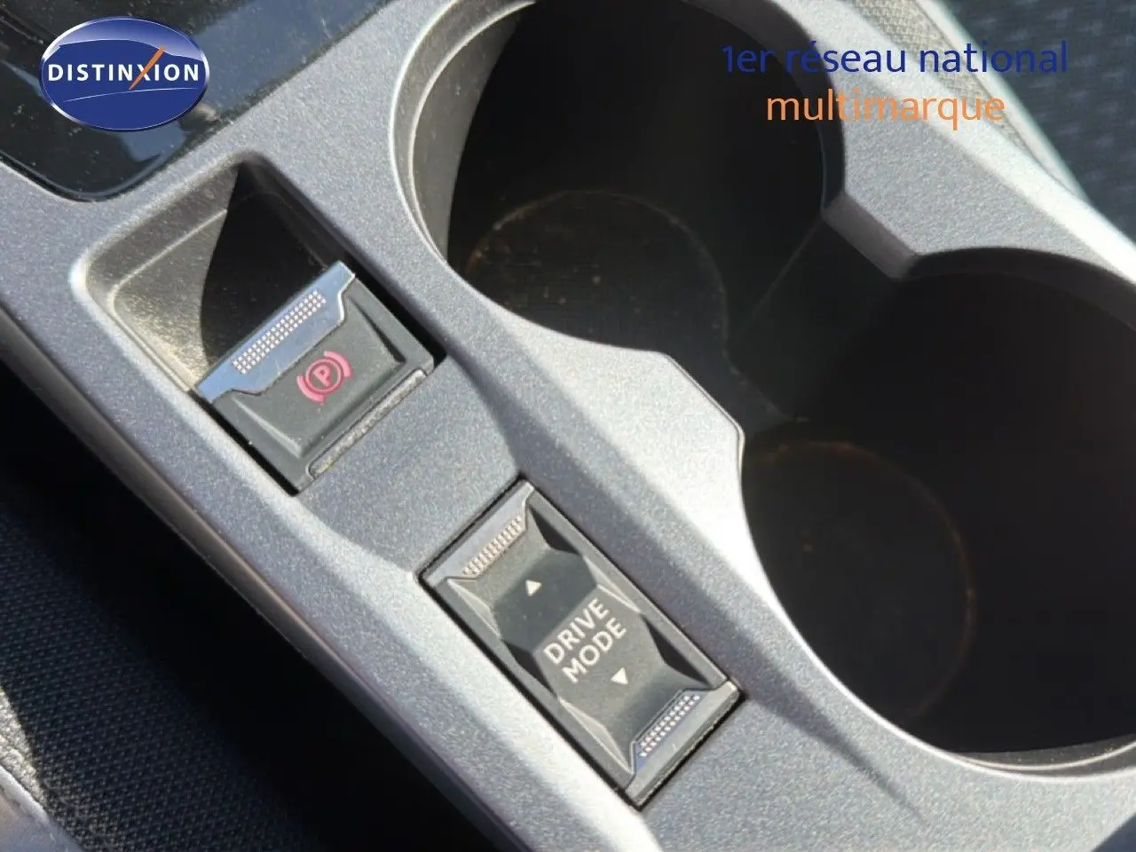 Gros plan sur la console centrale grise avec bouton de frein à main électrique et sélecteur Drive Mode du Peugeot 2008.