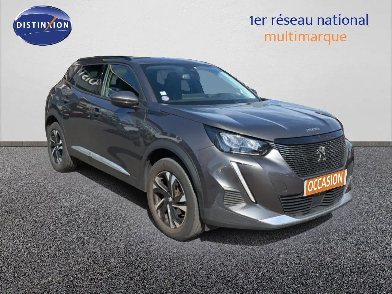Peugeot 2008 gris platinium en 3/4 avant droit, avec calandre noire et jantes bi-ton visibles.