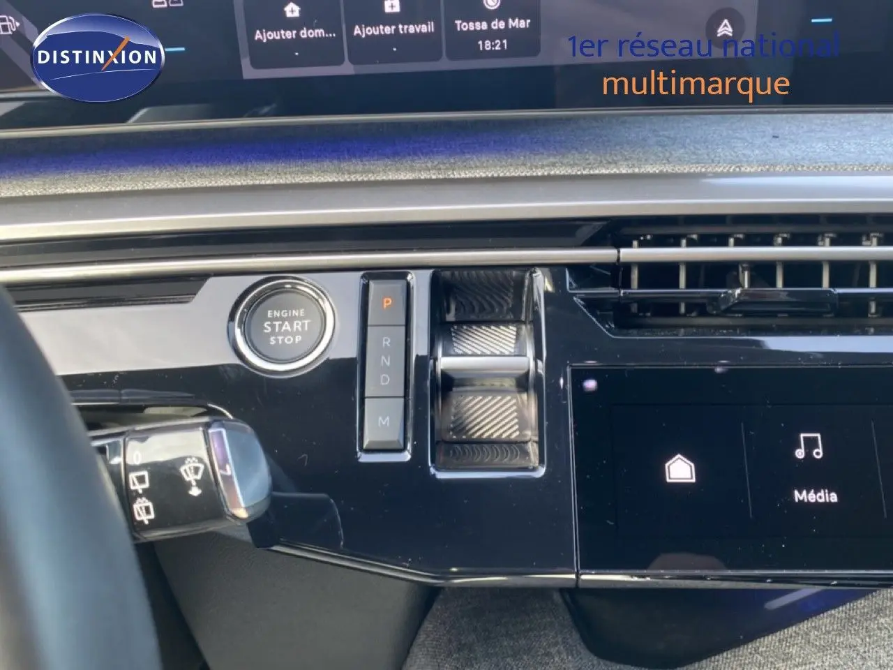 Détail du tableau de bord noir brillant du Peugeot 5008 Hybrid avec bouton start/stop et commandes de boîte automatique.