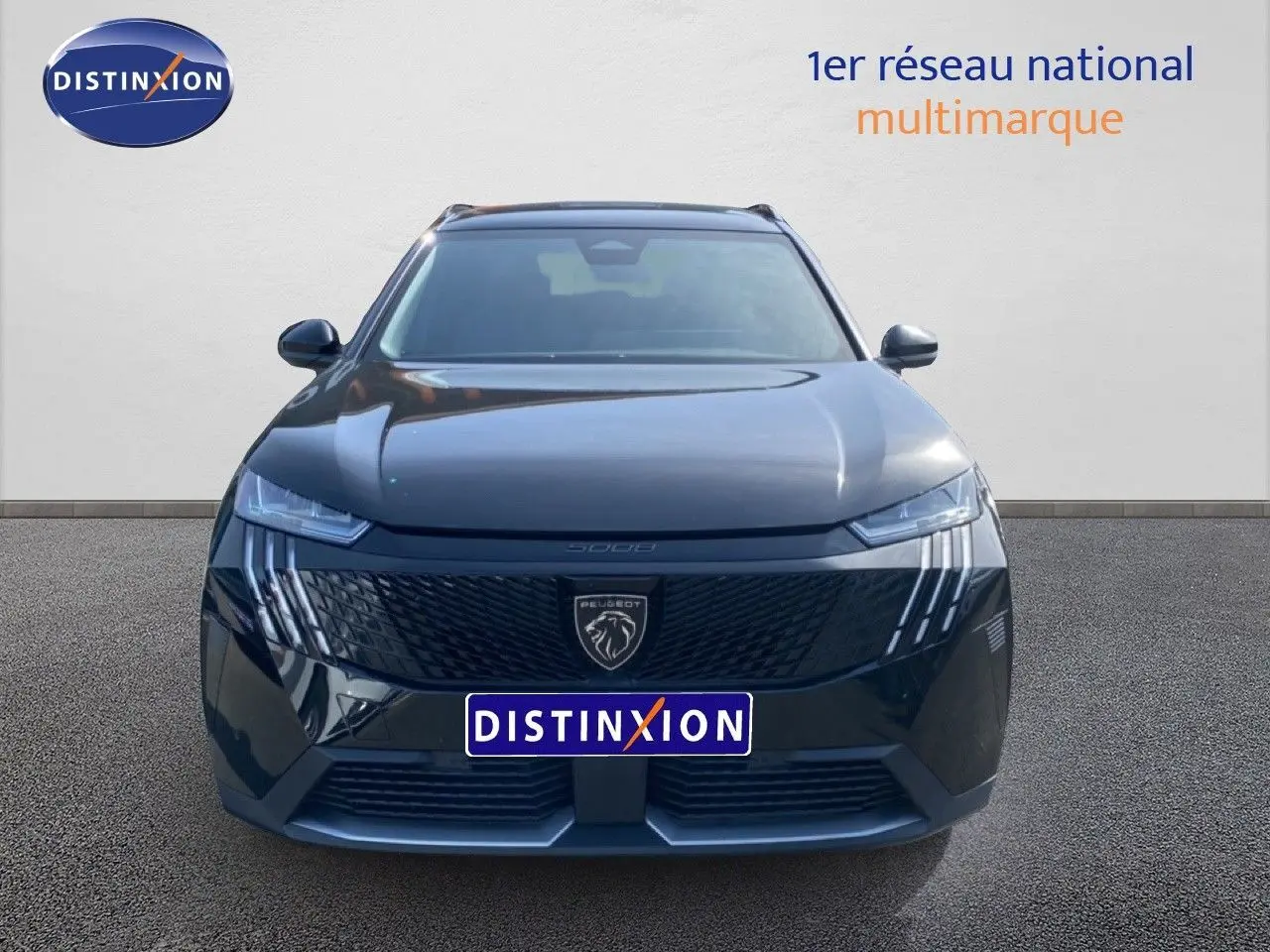 Vue frontale d’un Peugeot 5008 noir Perla Nera métallisé avec calandre distinctive et phares LED en griffes.