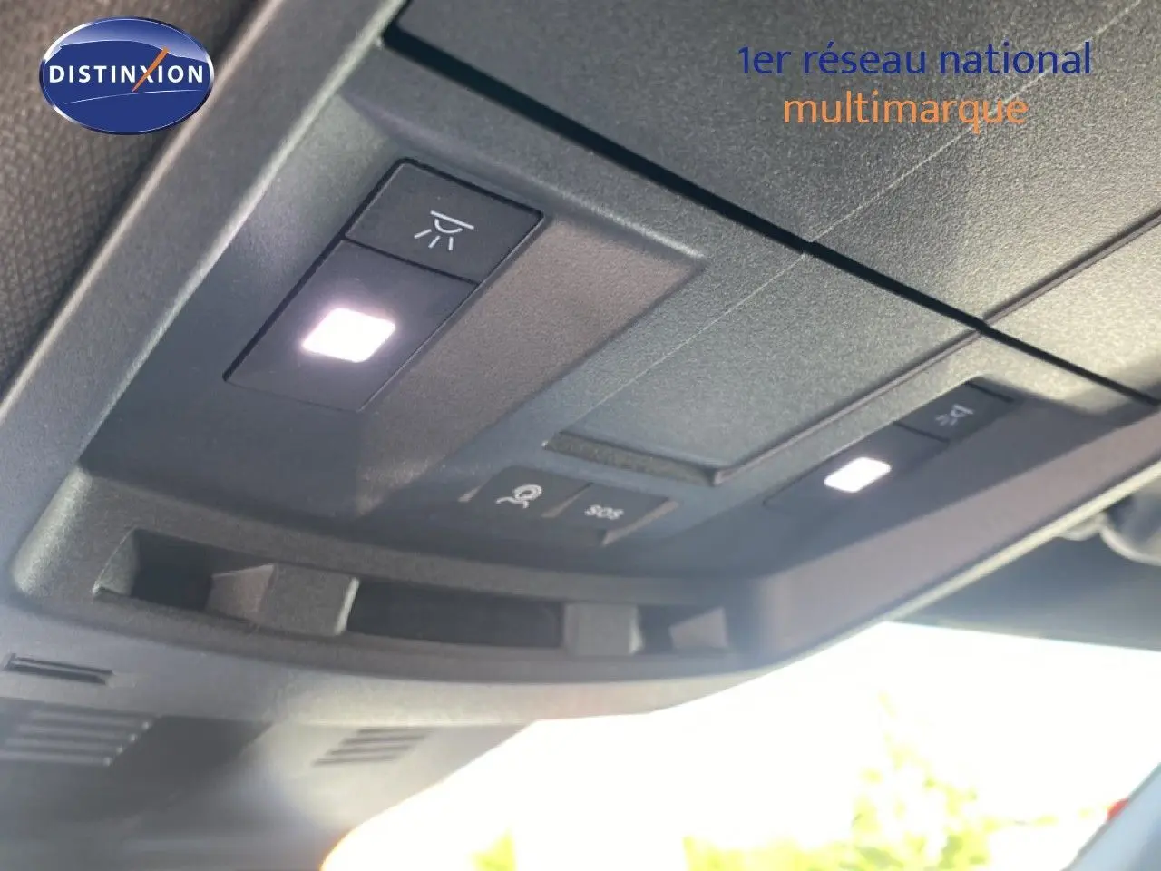 Vue en gros plan du plafonnier avec éclairage et commandes dans un Peugeot 5008 noir Perla Nera 2025 hybride.