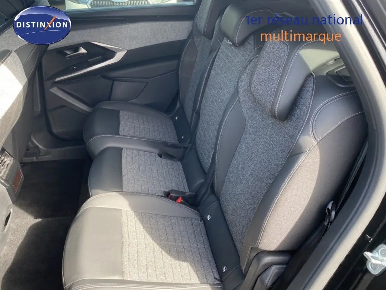 Vue intérieure arrière droite du Peugeot 5008 noir Perla Nera, sièges en tissu gris et cuir noir avec surpiqûres contrastées.