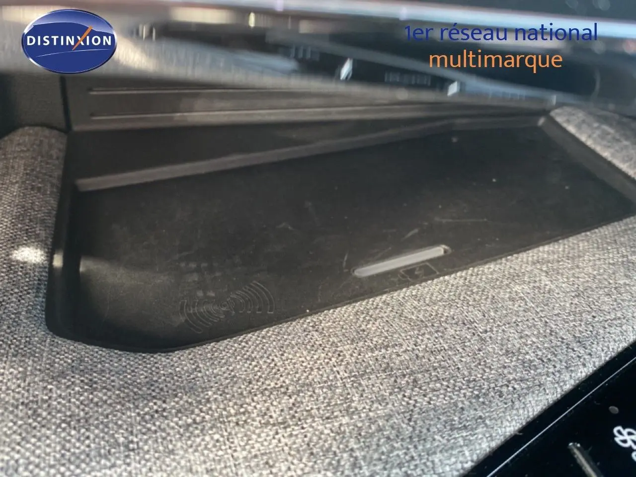 Détail intérieur montrant le chargeur sans fil intégré dans la console centrale du Peugeot 5008 Hybrid 2025 noir Perla Nera.