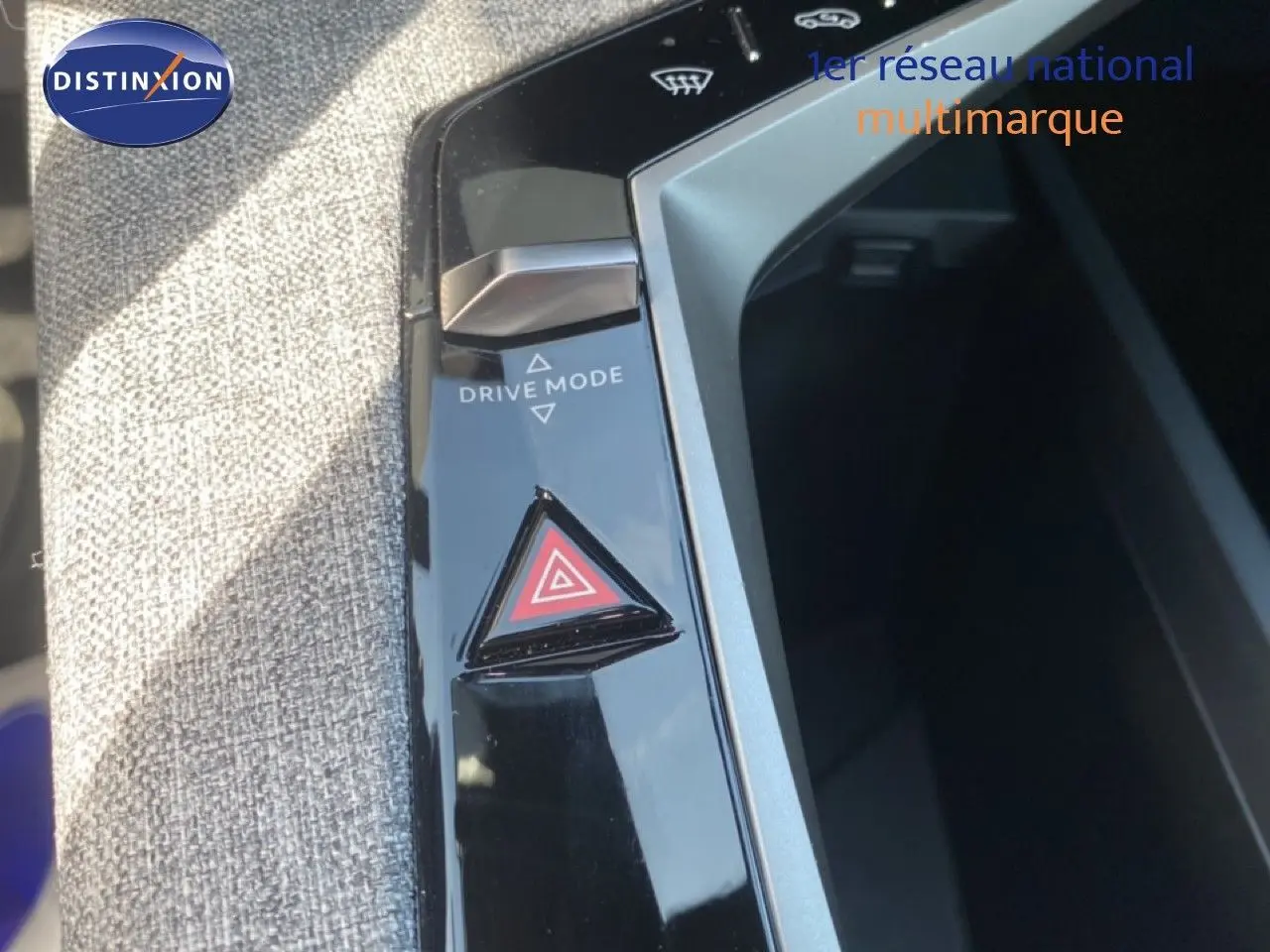 Gros plan sur la console centrale du Peugeot 5008 noir, montrant le bouton triangle de warning et la commande Drive Mode.